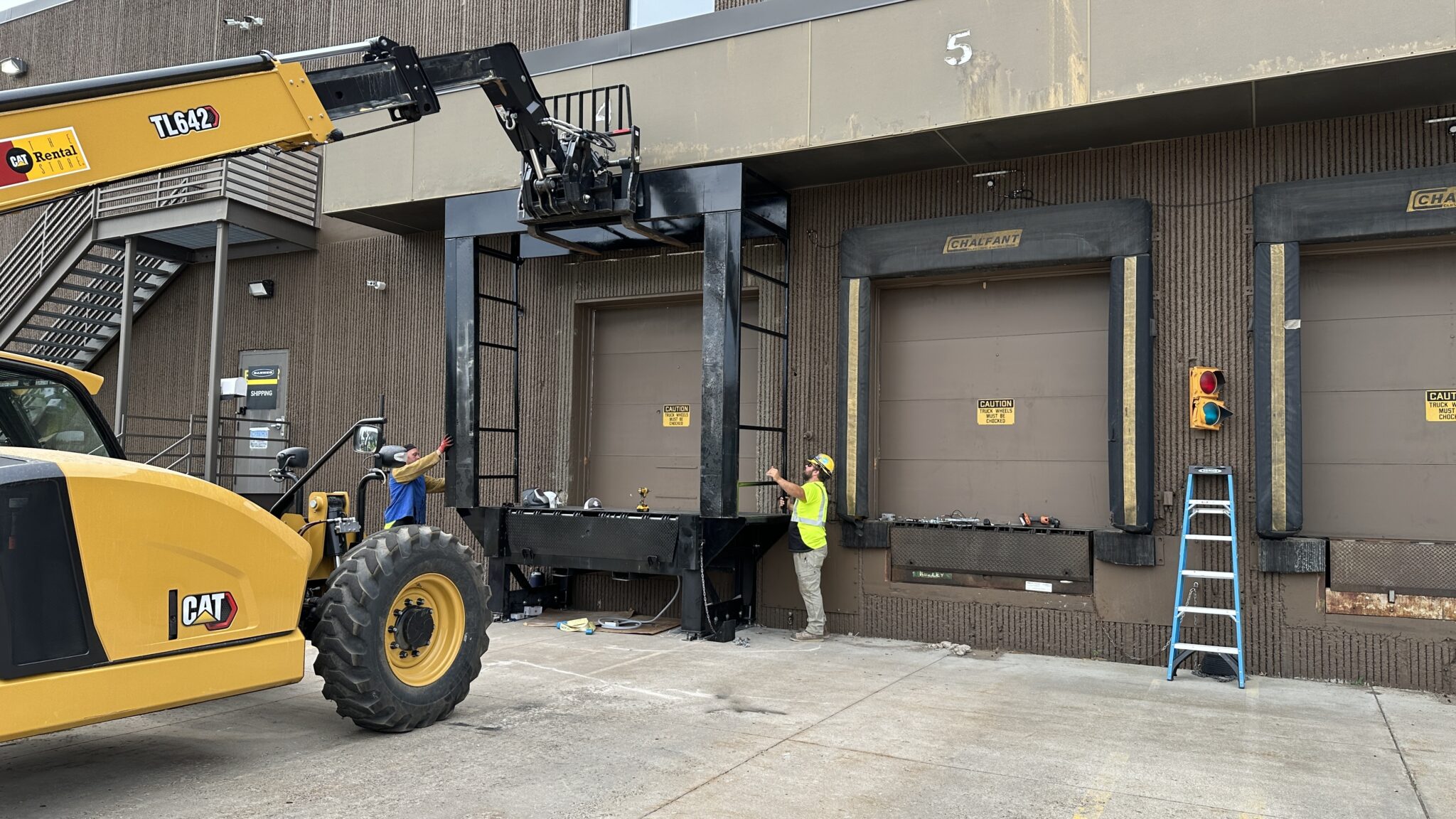 Installation of Dockzilla's Dock House Exterior Loading Dock Leveler frame on the outside of a facility